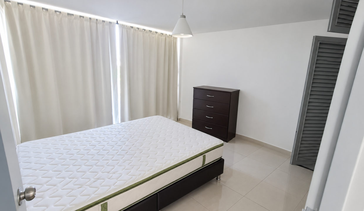 Dormitorio minimalista con cama y cortinas claras