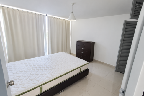 Dormitorio minimalista con cama y cortinas claras