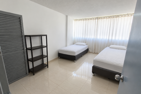 Dormitorio minimalista con camas y cortinas blancas